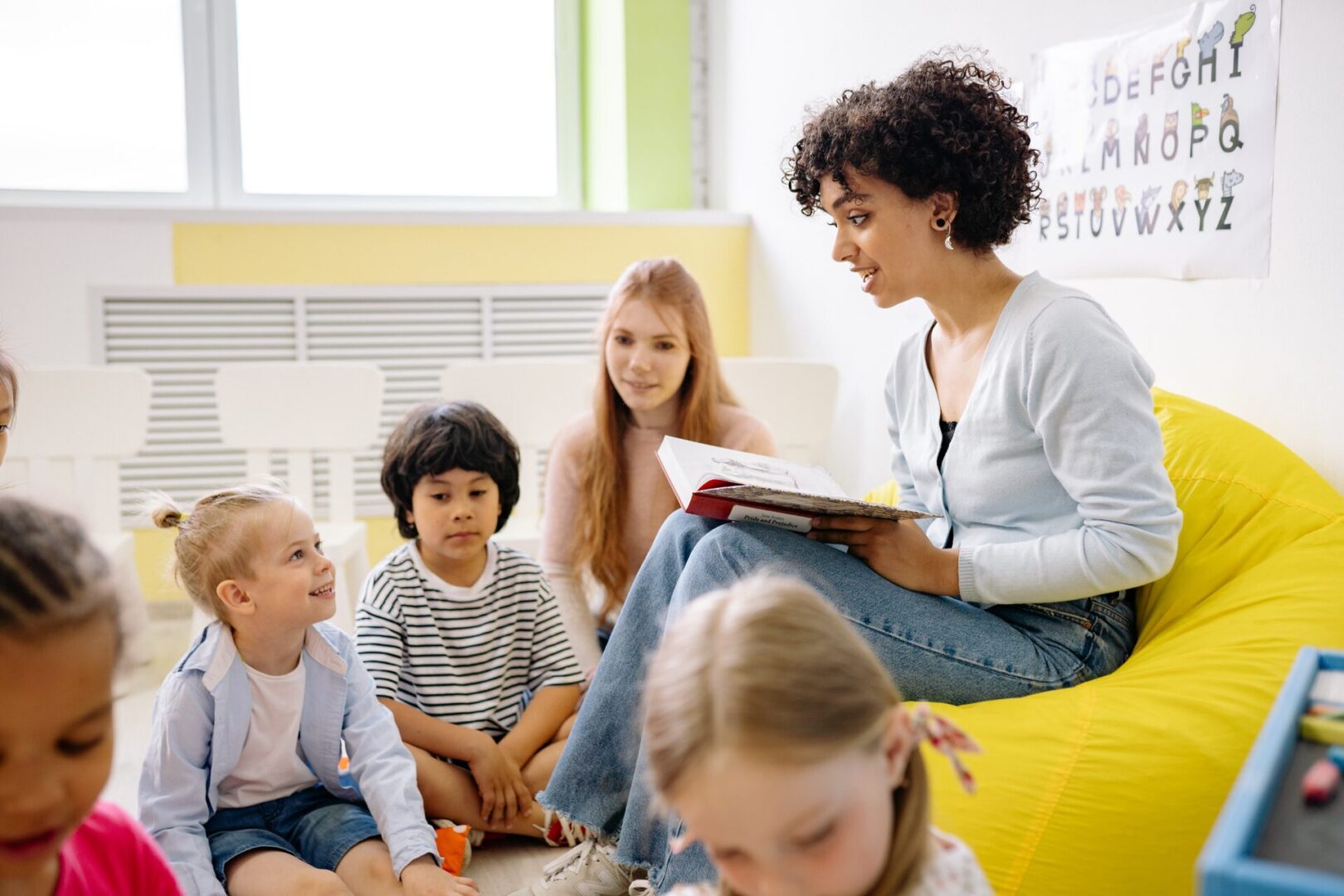 A woman reading to children in the classroom.
